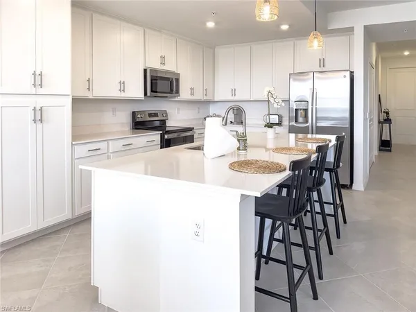 a kitchen with stainless steel appliances granite countertop a stove a sink a microwave and a refrigerator