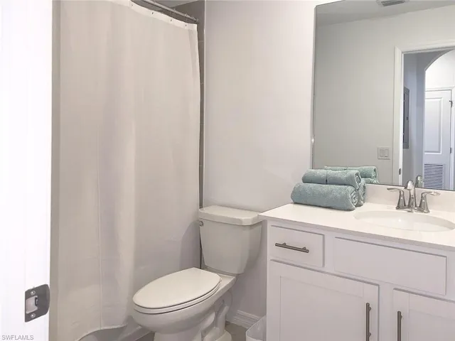 a bathroom with a toilet a sink and a mirror