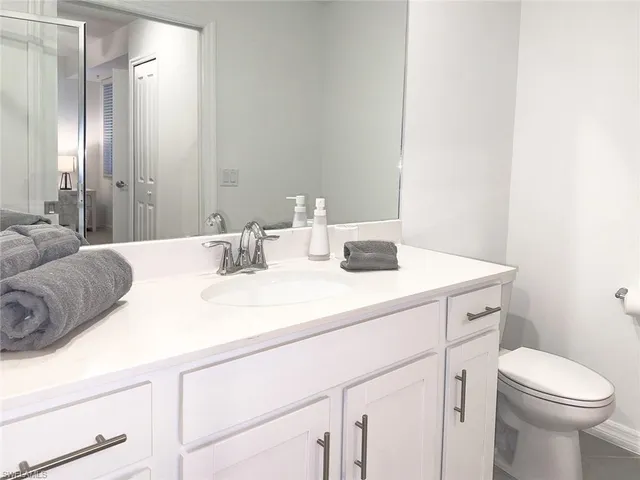 a bathroom with a sink a toilet and a mirror
