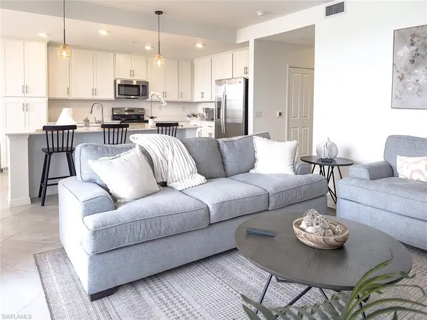 a living room with furniture kitchen and a chandelier