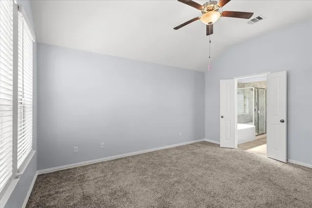 an empty room with a window and a fan