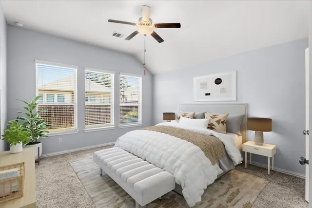 a bedroom with a large bed and a chandelier fan
