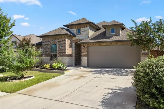 a front view of a house with a yard and potted plants