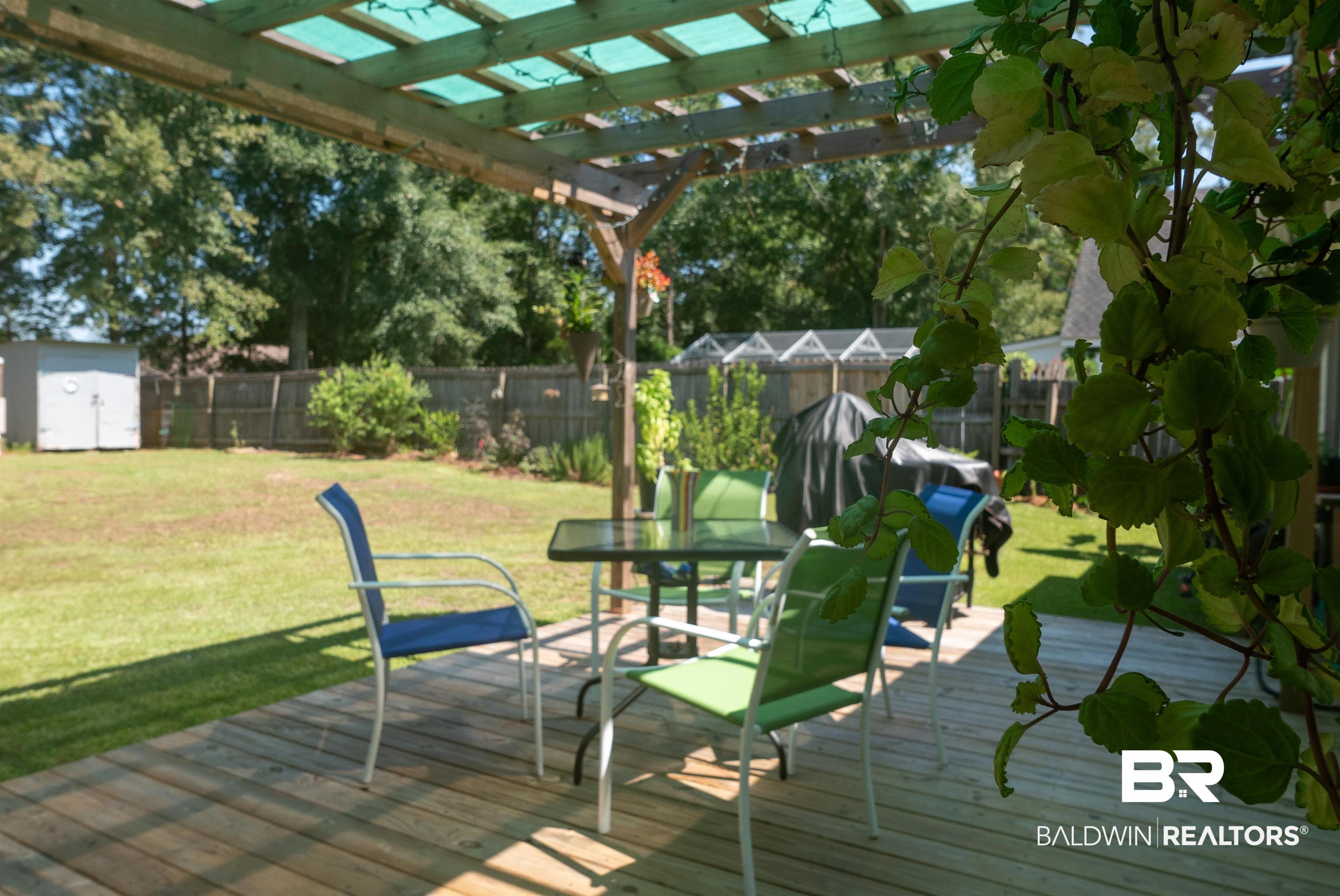 630 Spanish Main Daphne, AL 36527 - Photo 26 of 40 Wooden deck featuring a pergola, a storage shed, and a lawn