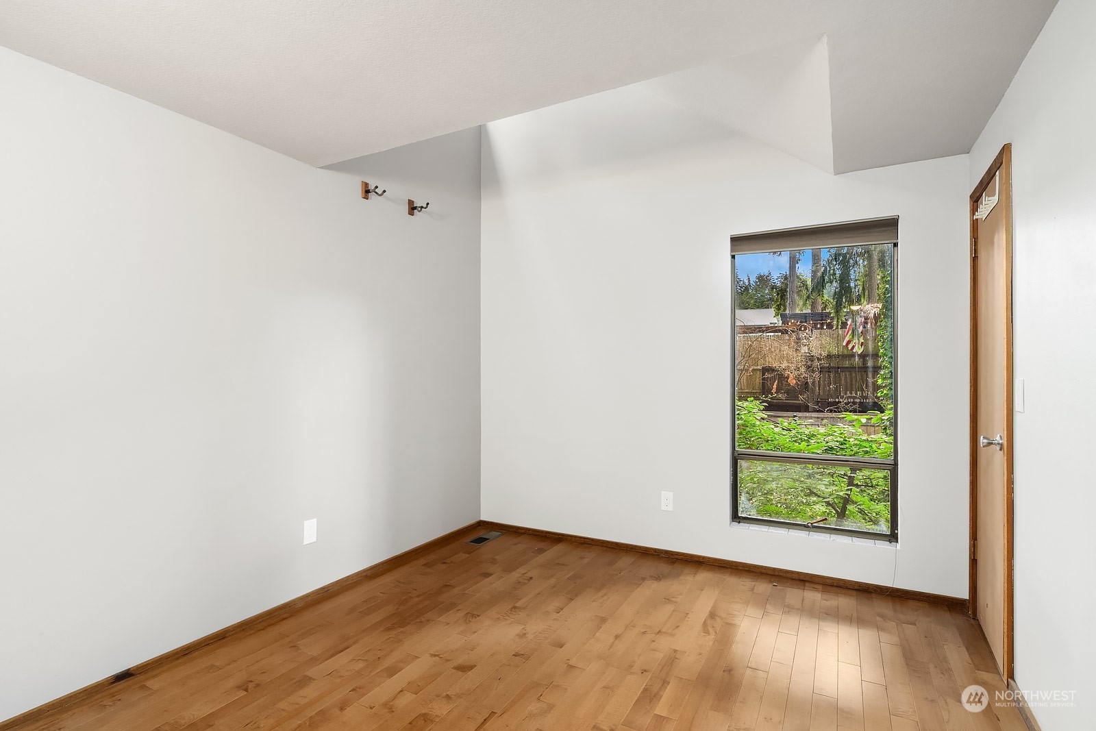 16117 Southeast 145th Place Renton, WA 98059 - Photo 23 of 38 a view of an empty room with wooden floor and a window