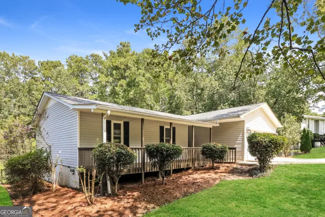 a view of a house with backyard and sitting area