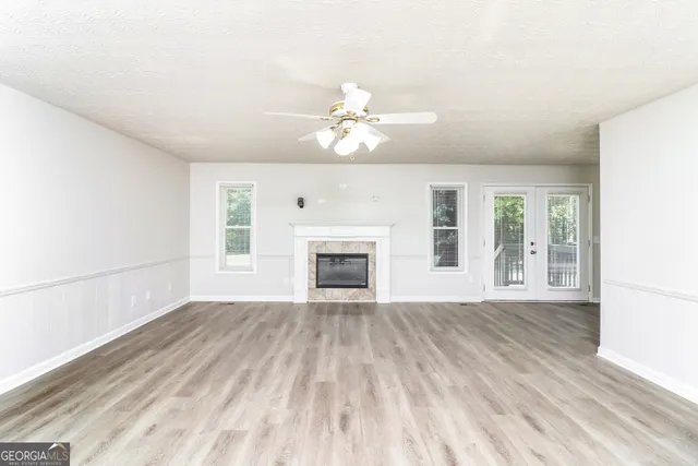 wooden floor fireplace and windows in an empty room