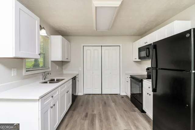 a kitchen with a sink a refrigerator and cabinets