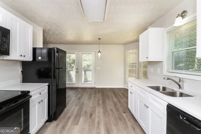 a kitchen with a refrigerator a sink and wooden cabinets