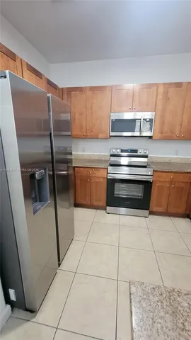 a kitchen with a stove a microwave and a refrigerator