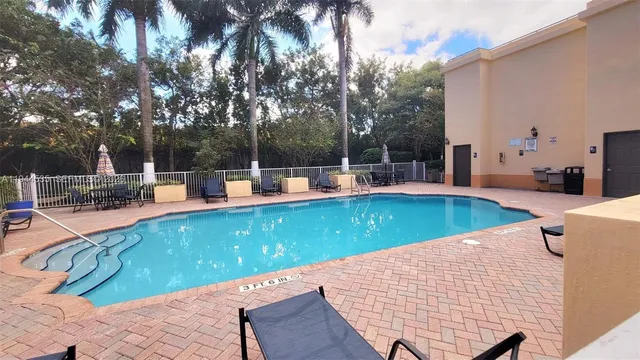 swimming pool view with a sitting space and garden view
