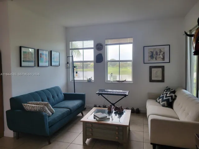 a living room with furniture and two window