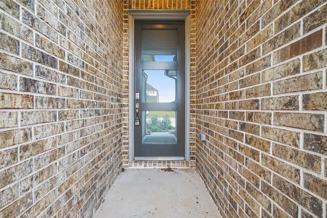 a view of an empty room with wooden floor and a ceiling fan