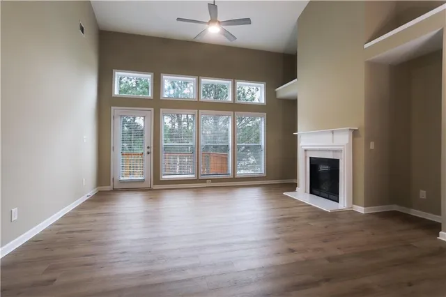wooden floor fireplace and windows in an empty room
