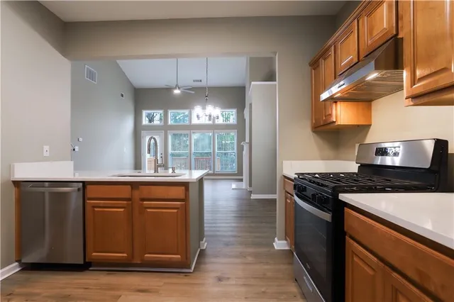 a kitchen with stainless steel appliances granite countertop a stove a sink and a refrigerator