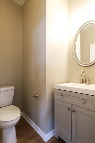 a bathroom with a toilet a sink and mirror