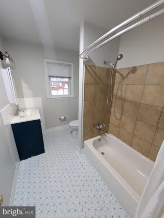 a bathroom with a tub a double vanity sink and shower