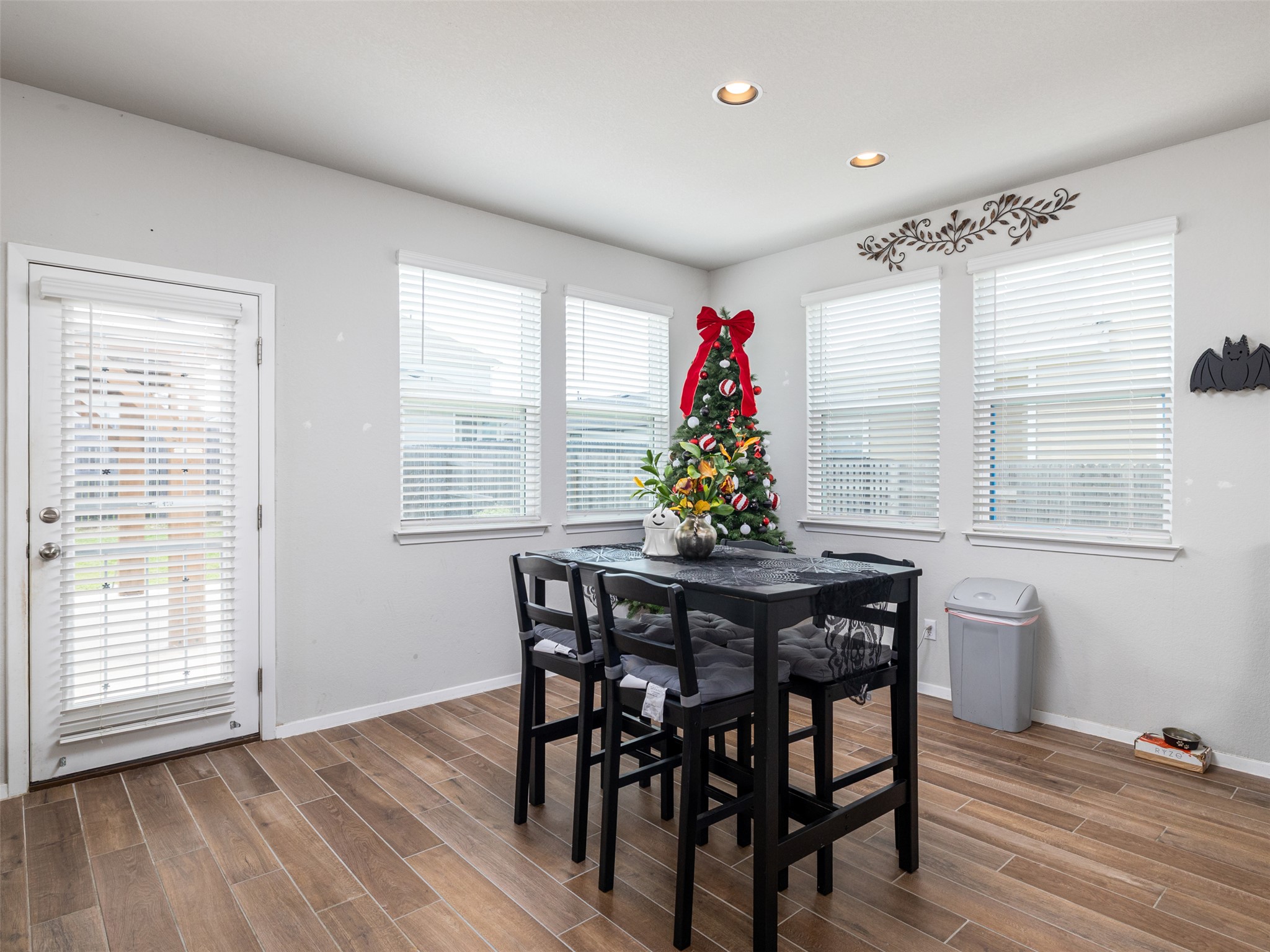121 Graver Street Georgetown, TX 78626 - Photo 7 of 28 Natural light floods this dining area, highlighting the warm wood-look tile flooring.