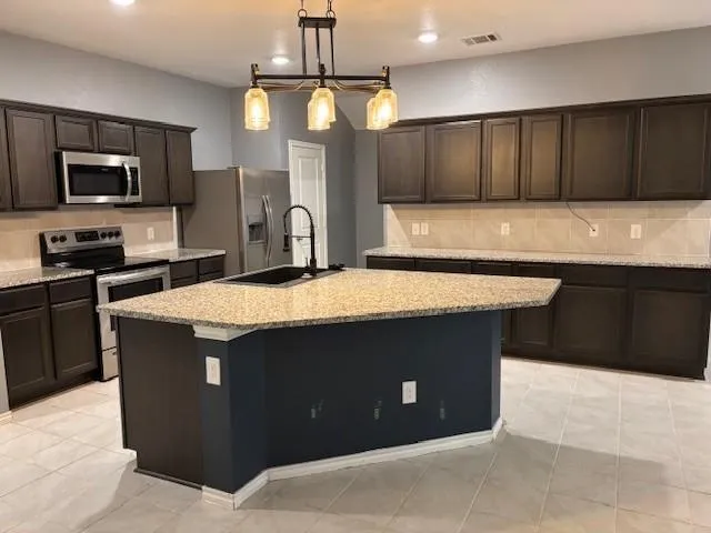 a kitchen with stainless steel appliances a sink stove and refrigerator