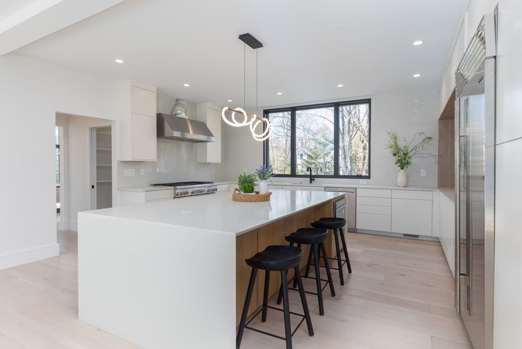 11 Willard Road Weston, MA 02493 - Photo 11 of 42 a kitchen with stainless steel appliances a table and chairs in it