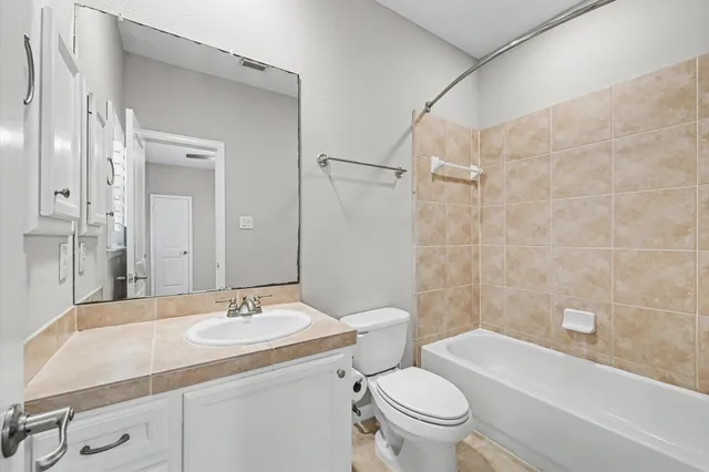 a bathroom with a sink toilet vanity and shower