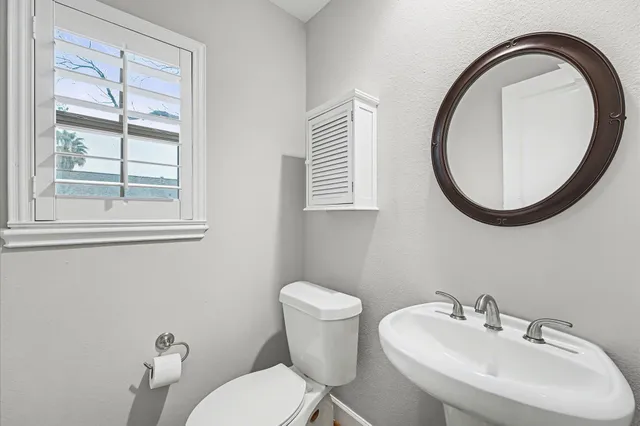 a bathroom with a sink a mirror and a toilet