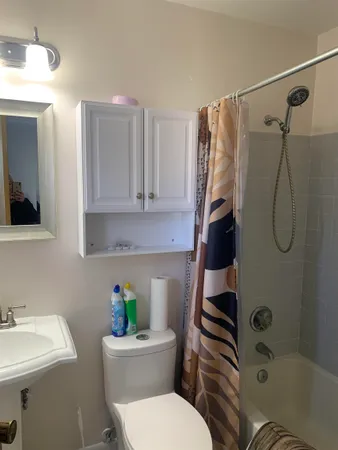 a white toilet sitting next to a bathroom sink and a shower