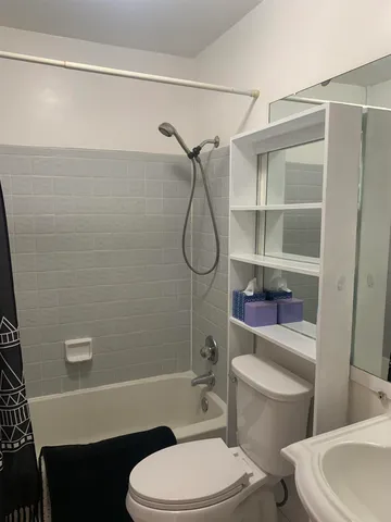 a white toilet sitting next to a bathroom sink and a shower