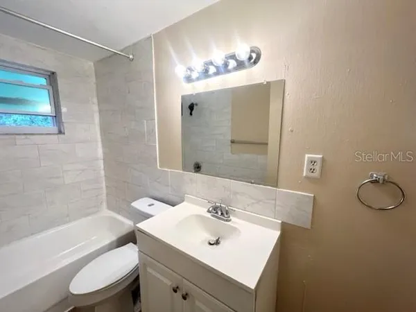 a bathroom with a sink mirror toilet and bathtub