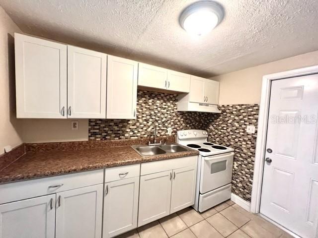 9418 Greystone Road Thonotosassa, FL 33592 - Photo 5 of 19 a kitchen with granite countertop white cabinets and white appliances