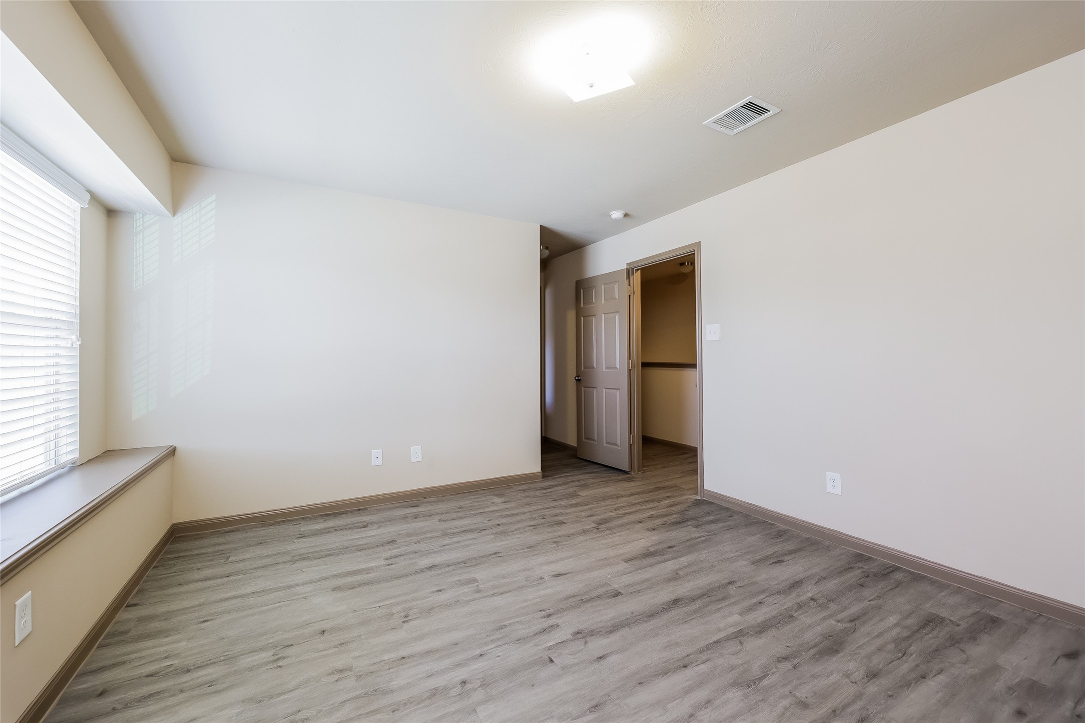 2422 West Werrington Way Houston, TX 77073 - Photo 9 of 13 a view of an empty room with wooden floor and a window
