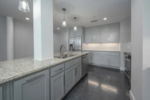 a kitchen with granite countertop a sink and white cabinets