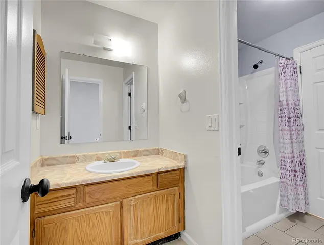 a bathroom with a granite countertop sink a mirror a shower and a bathtub