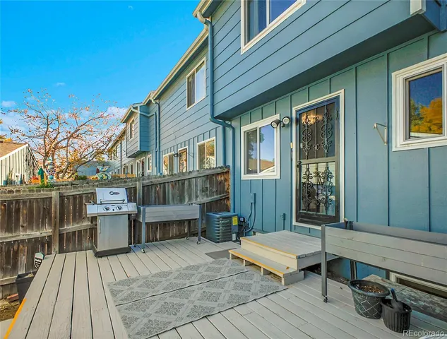 a backyard of a house with barbeque oven table and chairs