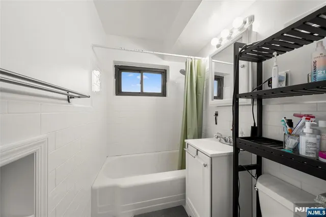 a bathroom with a bathtub sink mirror and toilet