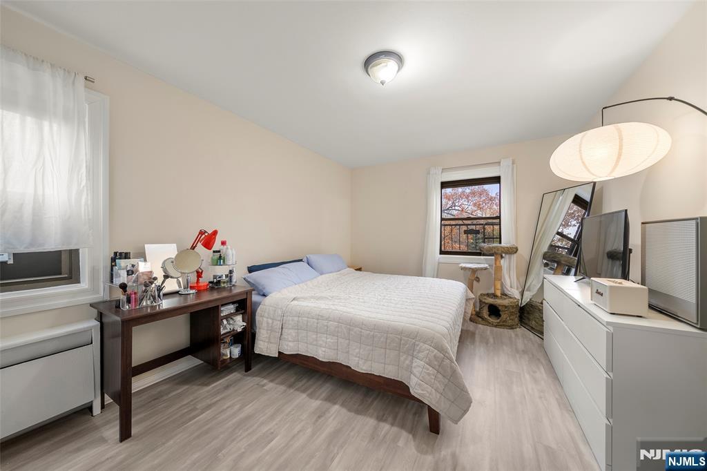 3040 Edwin Avenue, Unit 4A Fort Lee, NJ 07024 - Photo 12 of 15 a bedroom with a bed and a chandelier