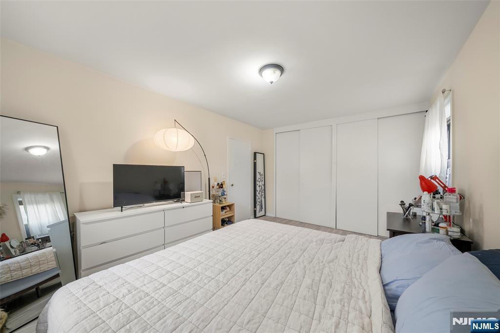 3040 Edwin Avenue, Unit 4A Fort Lee, NJ 07024 - Photo 13 of 15 a bedroom with a bed and a flat screen tv