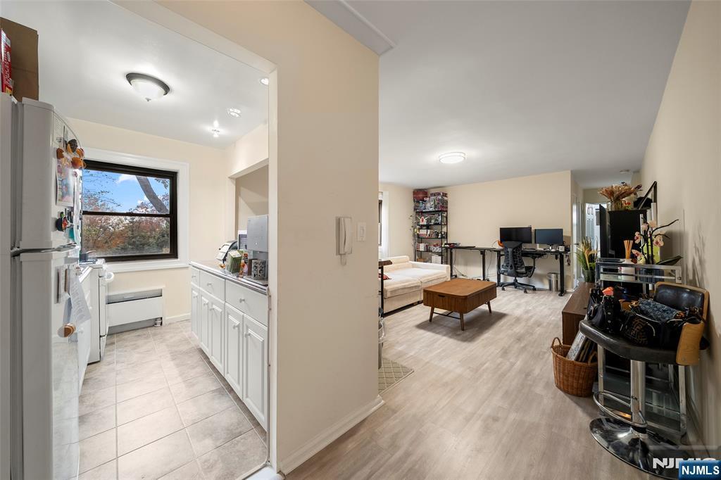 3040 Edwin Avenue, Unit 4A Fort Lee, NJ 07024 - Photo 4 of 15 a view of living room kitchen with furniture and a flat screen tv