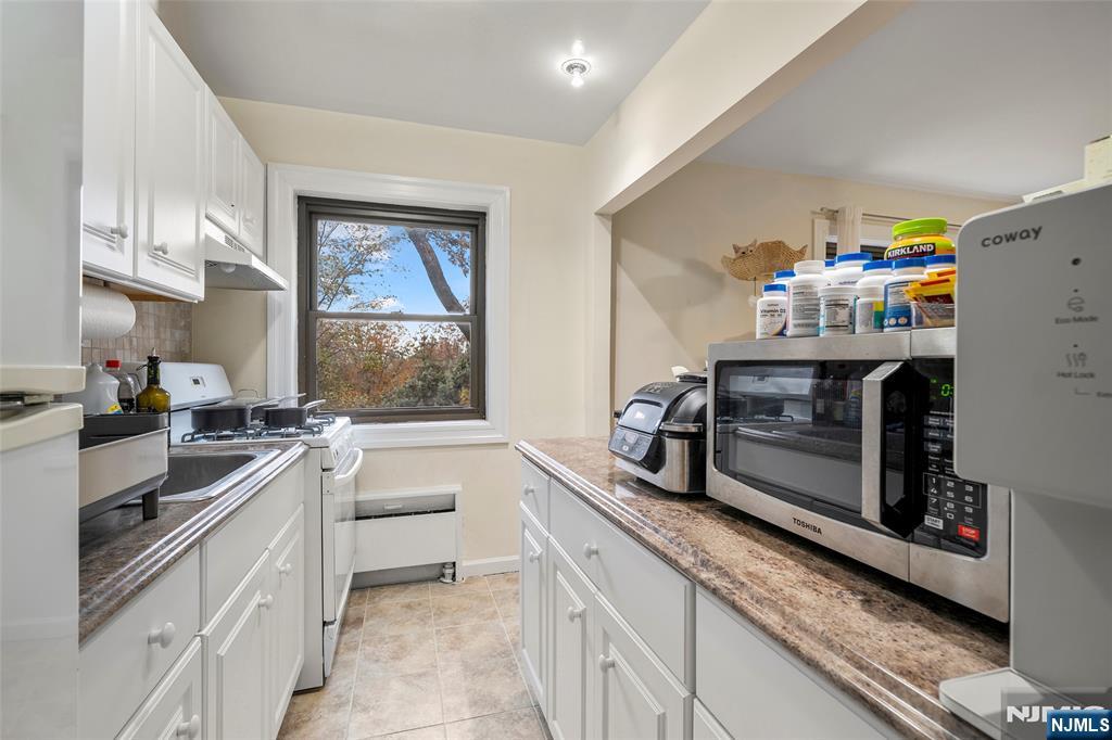 3040 Edwin Avenue, Unit 4A Fort Lee, NJ 07024 - Photo 5 of 15 a kitchen with a sink stove and microwave