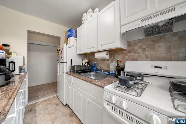 a kitchen with stainless steel appliances granite countertop a sink stove and cabinets