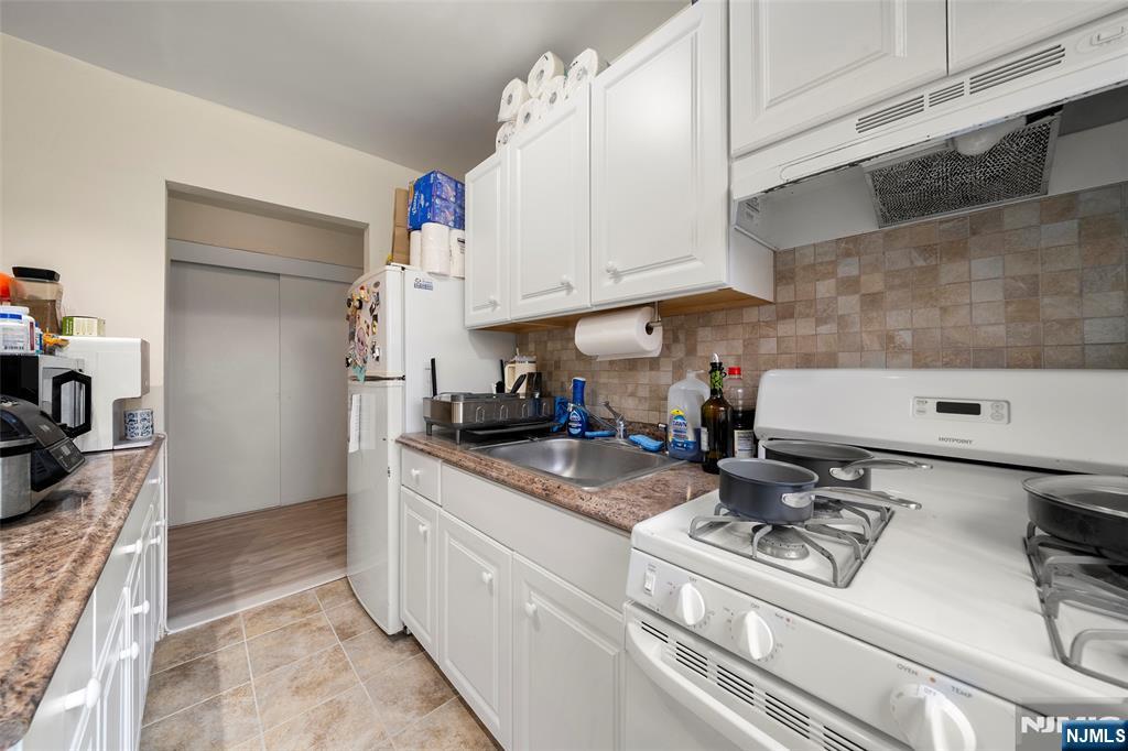 3040 Edwin Avenue, Unit 4A Fort Lee, NJ 07024 - Photo 6 of 15 a kitchen with stainless steel appliances granite countertop a sink stove and cabinets