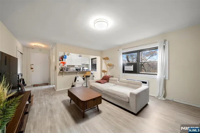 a living room with furniture a flat screen tv and a window