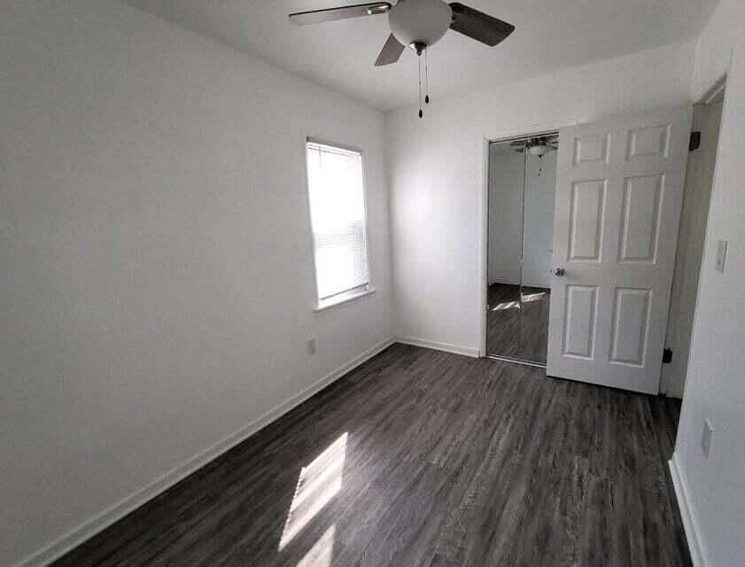 2267 Tennessee Street Gary, IN 46407 - Photo 7 of 11 an empty room with wooden floor cabinet and windows