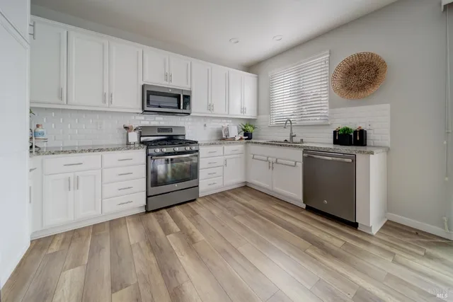 a kitchen with white cabinets stainless steel appliances and sink