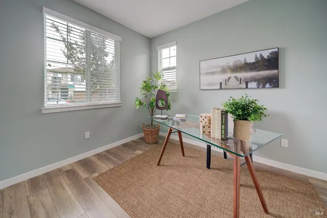a workspace room with furniture and a potted plant