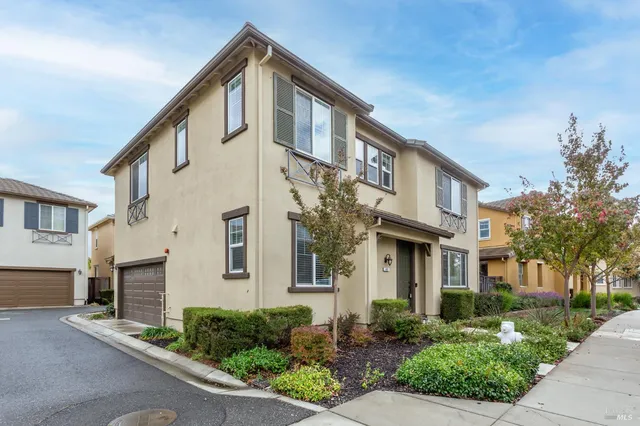 a front view of a house with garage and plants
