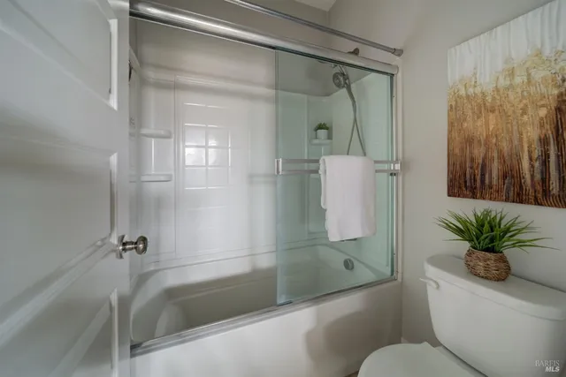 a bathroom with a shower a toilet and a tub