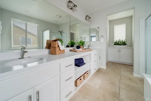 a spacious en suite bathroom with double vanity and a mirror