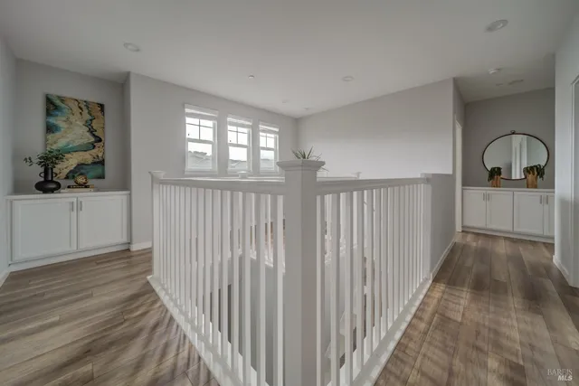 a view of a hallway with wooden floor and windows