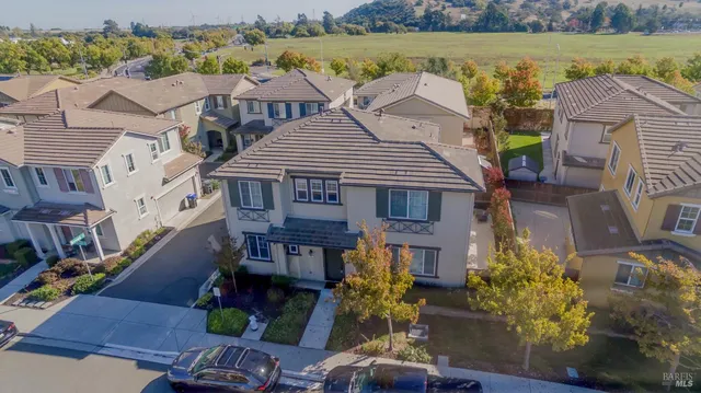 an aerial view of residential houses with outdoor space and ocean view